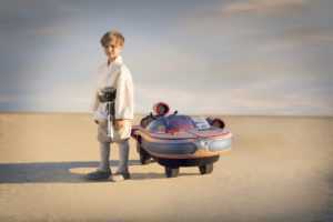 Little Boy Posing at the Side of Star Wars Luke Skywalker Landspeeder