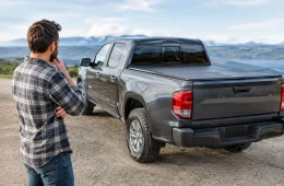Man Sizing Up A Gray Pickup Truck With A Black Hard Tonneau Cover On The Bed